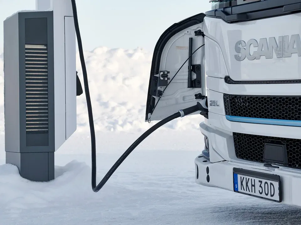 Electric truck connected to a charger in snowy test conditions